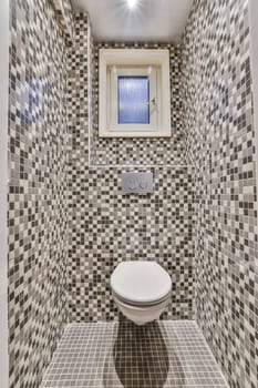 a small bathroom with a toilet and a tile wall