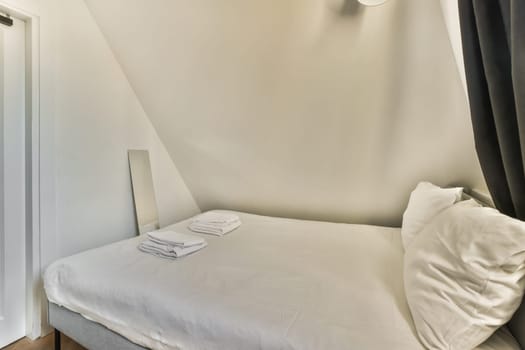 a small bed in a room with a white sheet