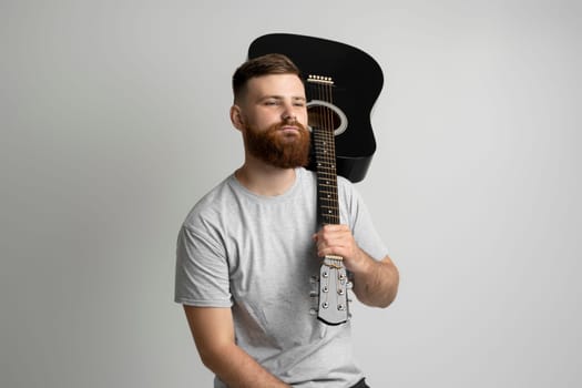 Bearded musician man having fun and playing acoustic guitar. Music performer musician. Musical string instrument.