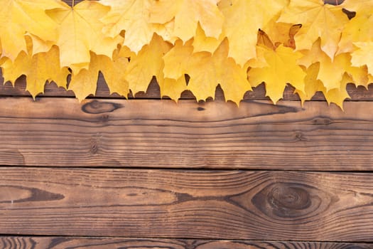 Autumn leaves frame on wooden background top view Fall Border yellow and Orange Leaves vintage wood table Copy space for text.