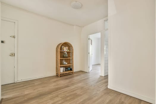 Amsterdam, Netherlands - 10 April, 2021: an empty living room with wood flooring and white walls in the room has a mirror on the wall above it
