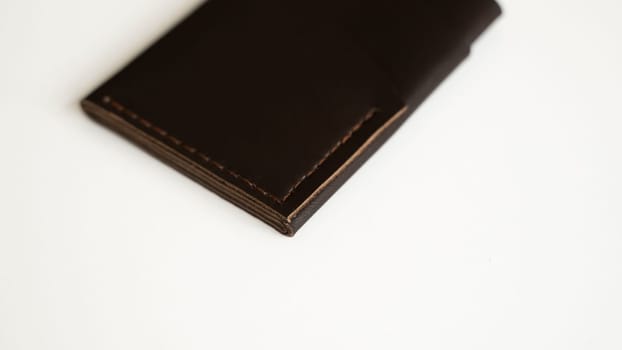 Brown empty men's business handmade leather card holder with isolated on white background. Selective focus, copy space, close up.