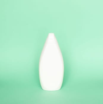 Blank shampoo bottle or shower gel on pastel green background. Container, beauty product and body care cosmetics.
