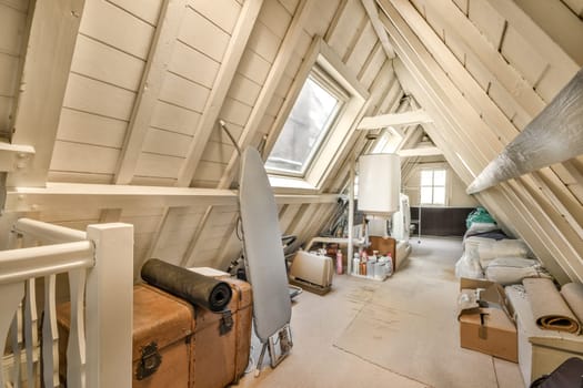the attic of a house with furniture and a window