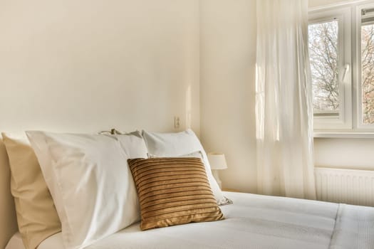a bed with white sheets and a brown pillow