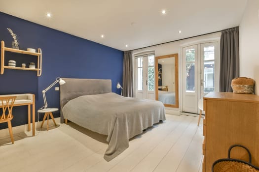 a bedroom with a bed and a blue accent wall