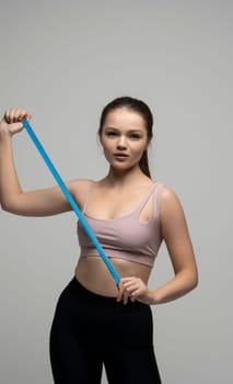 Happy slim brunette woman in sport wear with measuring tape on white background. Positive weight loss diet results. Healthy lifestyles concept.