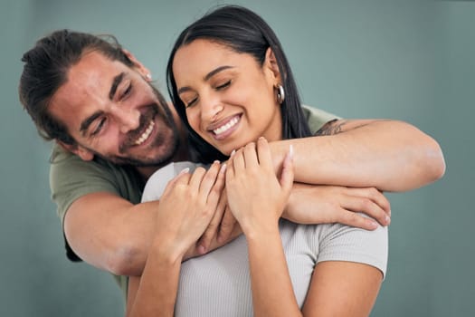 Love, hug and support of a couple in a home with smile, care and affection. Trust, help and embrace of marriage or young interracial people, comforting partner together in their house with happiness