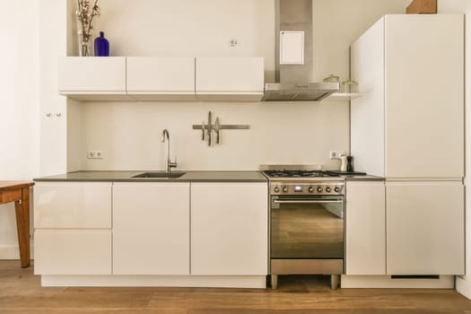 a kitchen with white cabinets and a stainless steel oven