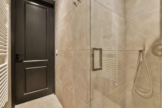 a bathroom with a shower and a black door