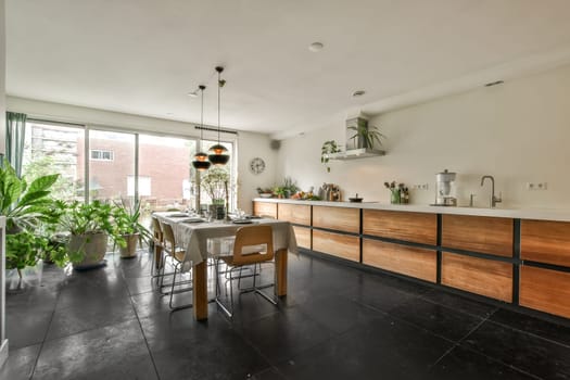 Amsterdam, Netherlands - 10 April, 2021: a kitchen and dining area in a house with large sliding glass doors that open up to the outside patio space