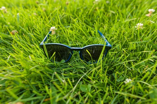 Sunglasses in bright green grass, summer accessory