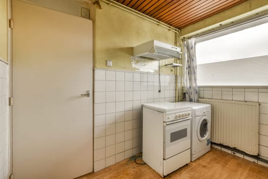 an old kitchen with a washing machine and a window