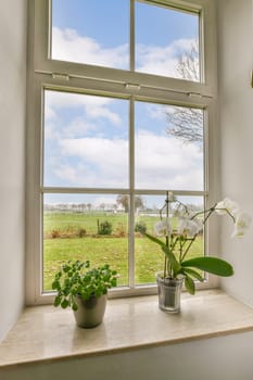 a view of the countryside from a window with flowers