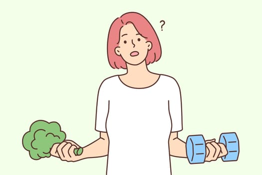 Woman holding dumbbells and broccoli wanting to choose way to lose weight