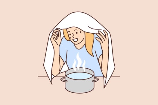 Woman sits over pot hot water covering head with towel to get rid cold or runny nose