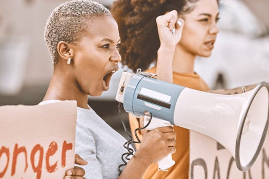 Protest, angry and black woman with a megaphone as leadership for social change, justice and freedom from government. Conflict, fight and African girl shouting during a rally against racism in city