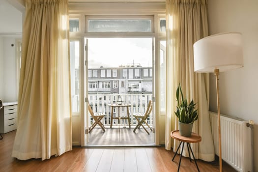 a room with a view of a balcony and curtains
