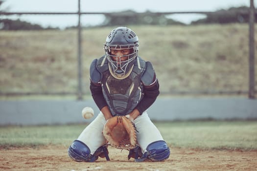 Baseball, sports and catch a ball with a man athlete or catcher on a field during a game or match. Fitness, exercise and training with a male baseball player playing a competitive sport on a pitch