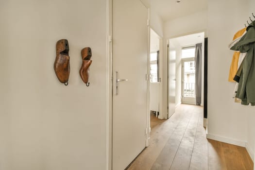 a hallway with two wooden shoes hanging on the wall