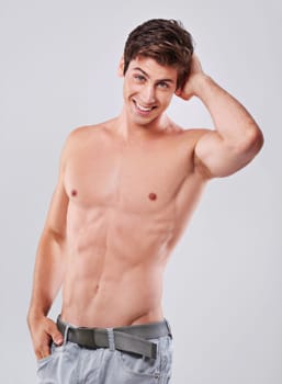Ive got the body that rocks. Studio shot of a handsome bare chested young man grooming.