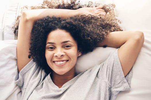 Black woman, top view and wake up portrait in bedroom after sleeping in the morning. Peace, bed relax and comfort of happy female awake after sleep on comfortable pillow and blankets for healthy rest