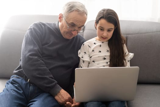 grandfather and granddaughter with laptop