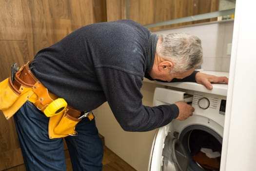 Plumber Fixing Domestic Washing Machine