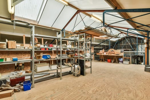 a large workshop with wood floors and metal shelving