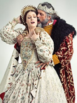 Medieval king, queen and violence in studio for drama, danger and together with renaissance clothes. Ancient royal couple, surprise and shock with distress, crying and actor with vintage fashion