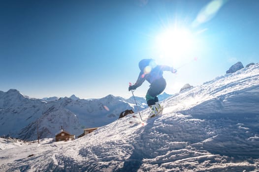 young female skier quickly descends the slope in the alpine mountains. Winter sports and recreation, active recreation