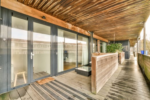 a long porch with glass doors and a wooden deck