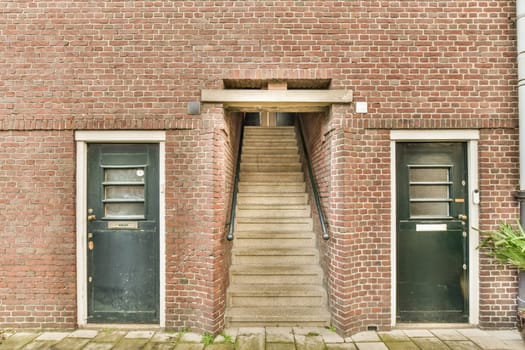 an old brick building with stairs and two doors