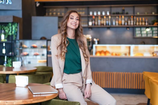 Business Woman Restaurant Owner With Laptop In Hands Dressed Elegant Pantsuit Sitting On Table In Restaurant With Bar Counter Background
