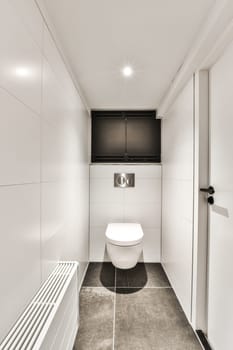 a white bathroom with a toilet and a television