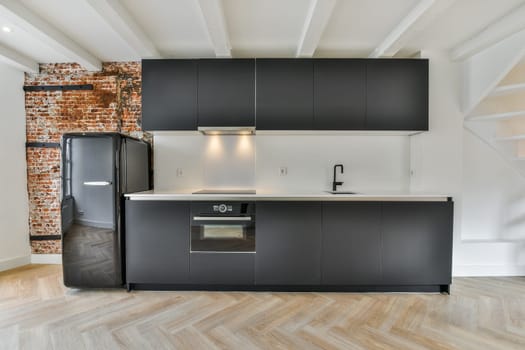 a kitchen with black appliances and a brick wall