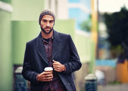 Coffee keeps the cold at bay. a handsome young man in winter wear holding a hot drink.