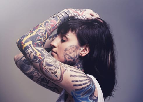 Stylized beauty. A cropped studio portrait of a tattooed young woman.