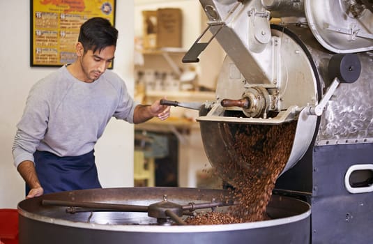 Master of coffee. a machine grinding and roasting coffee beans.