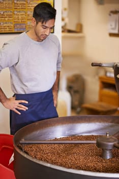 Slow roasting. a machine grinding and roasting coffee beans.