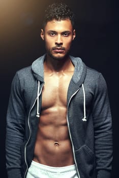 Hes in top shape. Studio shot of a fit young man isolated on black.