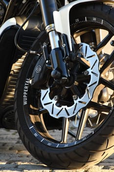 Vertical closeup of a front wheel of a chopper motorcycle