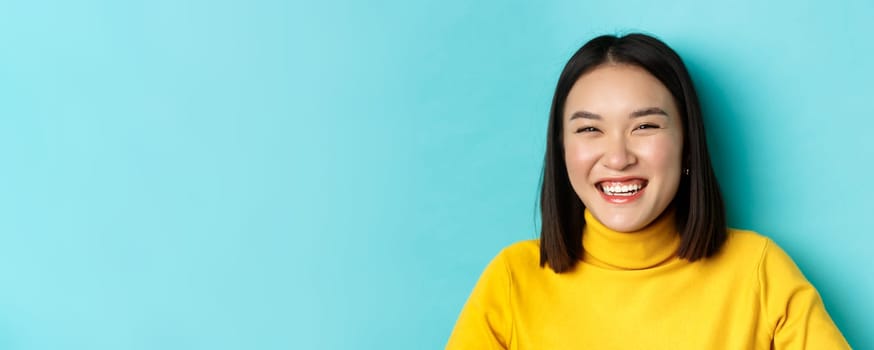 Beauty and makeup concept. Close up of carefree teenage girl smiling and laughing sincere, having fun, standing over blue background
