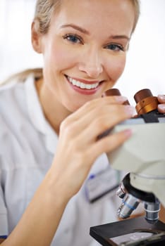 Positivity magnified. a beautiful woman in a laboratory working with a microscope.