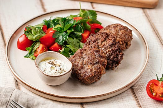 Russian beef cutlets with sauce and salad