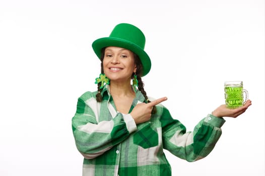Attractive woman in green carnival hat and plaid shirt, showing you a traditional Irish drink for Saint Patrick's Day