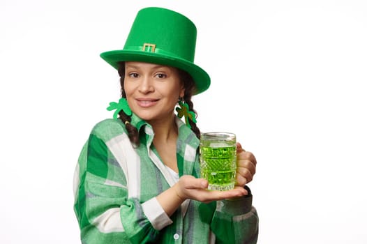 Isolated portrait on white background of beautiful brunette woman holding mug of green Irish beer and looking at camera