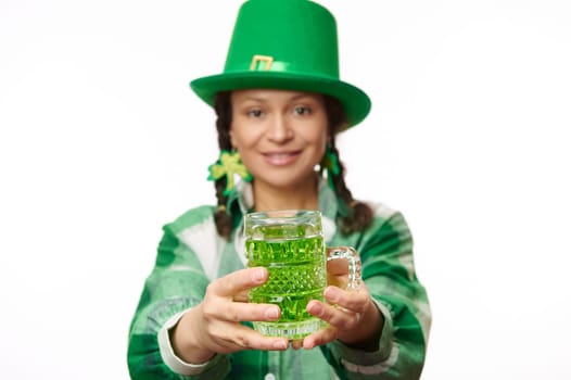 Focus on hands of blurred pretty woman serving you traditional Irish green beer in the pub for Saint Patrick's Day.