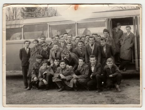 Vintage photo shows young students pose in front of bus. Photo has error obtained during photo process.