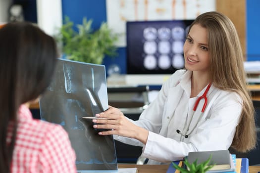 Female patient and doctor with spine x-ray scan meet in hospital